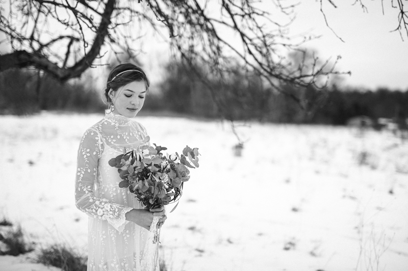 Winterbraut im Schnee mit Brautstrauß